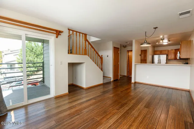 a view of a hallway with wooden floor and staircase