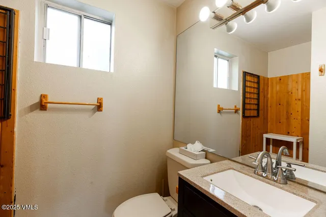 a bathroom with a sink toilet and mirror