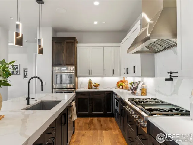 a kitchen with kitchen island granite countertop a sink stainless steel appliances and cabinets
