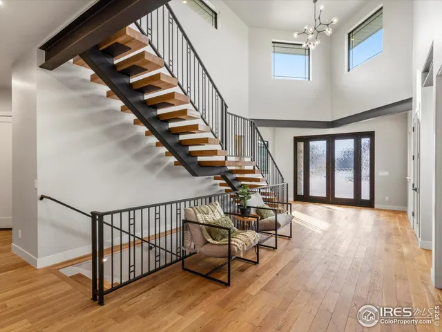 a view of staircase with wooden floor and a chandelier