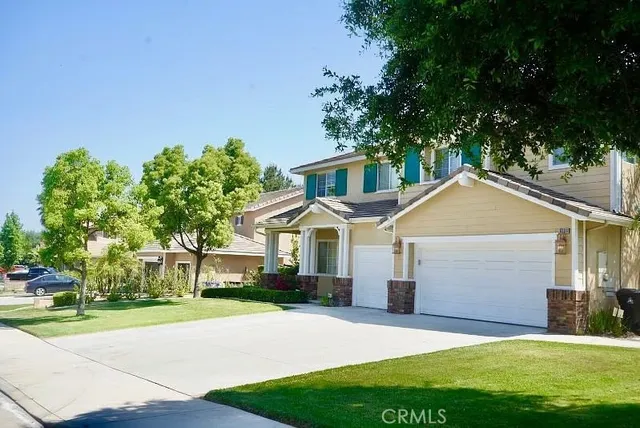 a front view of a house with a yard and trees