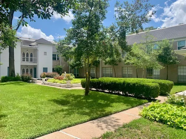 a front view of a house with a garden and plants