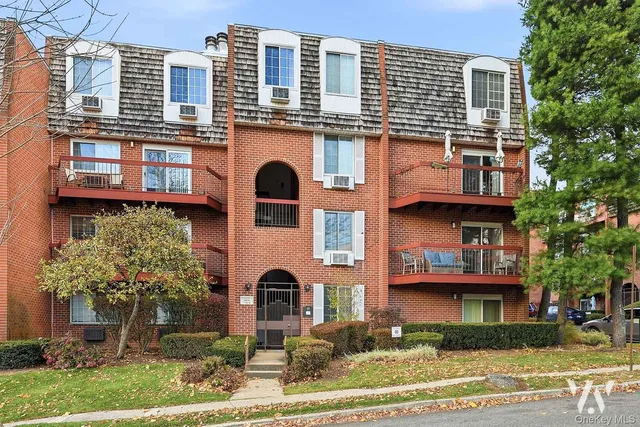 a front view of a residential apartment building with a yard