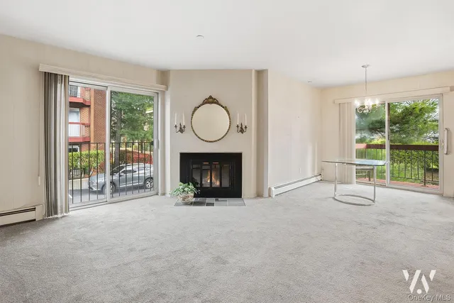 a view of an empty room with a fireplace and a window