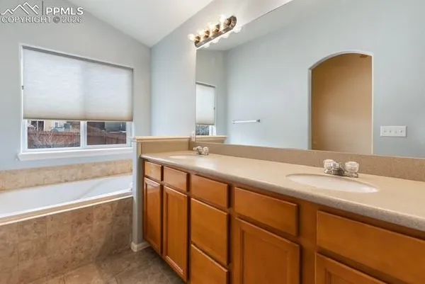 a bathroom with a granite countertop sink a large mirror and a bathtub