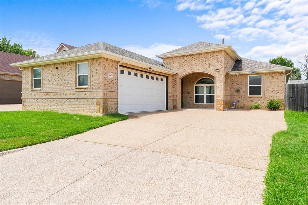 3807 Winding Road Arlington, TX 76016 - Photo 2 of 23 Brick facade residence featuring an arched entryway, an attached garage with a panel door, and a concrete driveway