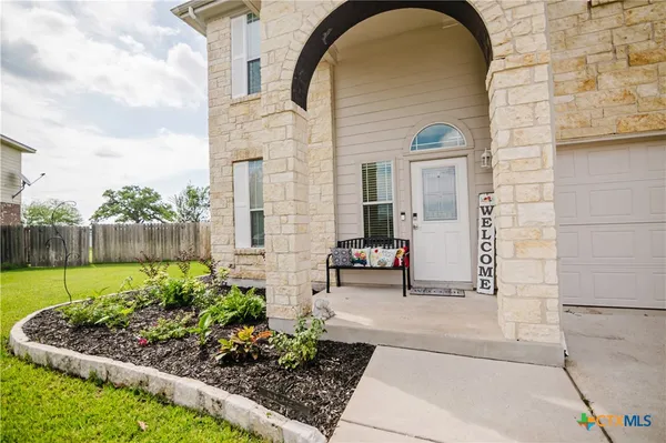a front view of a house with a garden