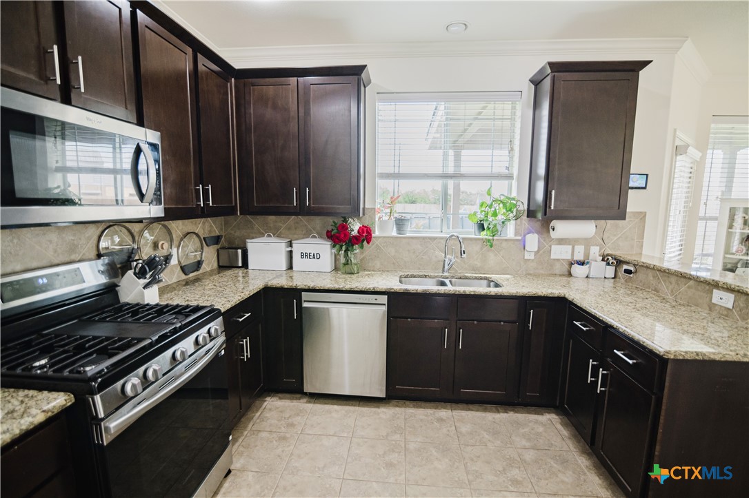 201 Boulder Ridge Drive Cuero, TX 77954 - Photo 11 of 37 a kitchen with a sink stove top oven and cabinets