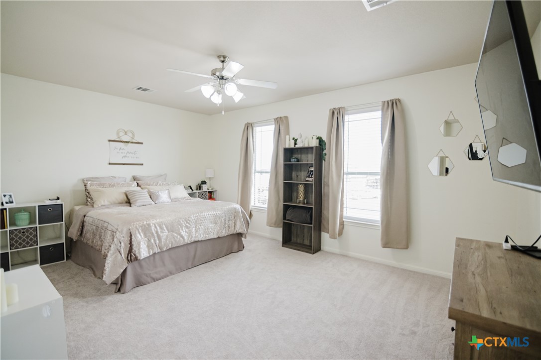 201 Boulder Ridge Drive Cuero, TX 77954 - Photo 18 of 37 a spacious bedroom with a bed and a chandelier