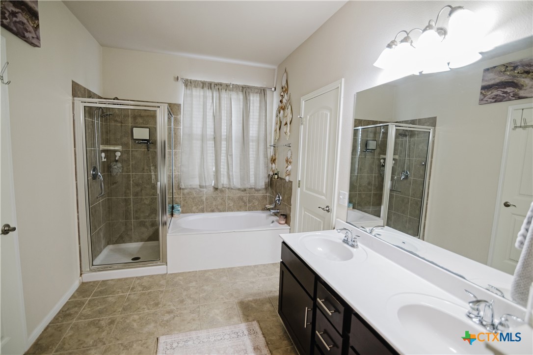 201 Boulder Ridge Drive Cuero, TX 77954 - Photo 22 of 37 a bathroom with a tub a sink and a mirror