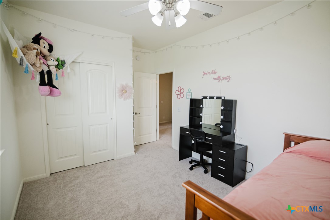 201 Boulder Ridge Drive Cuero, TX 77954 - Photo 28 of 37 a bedroom with a bed and a chandelier