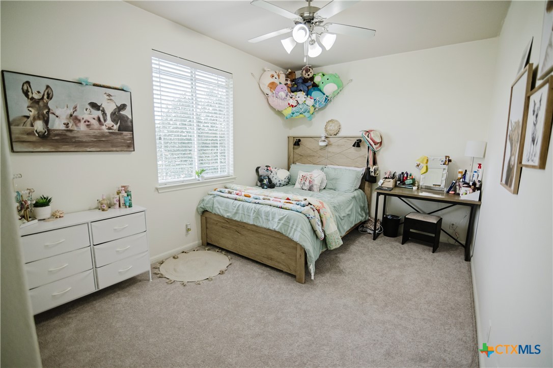201 Boulder Ridge Drive Cuero, TX 77954 - Photo 33 of 37 a bedroom with a bed and a chandelier