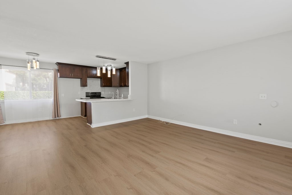 a view of a kitchen with wooden floor and electronic appliances