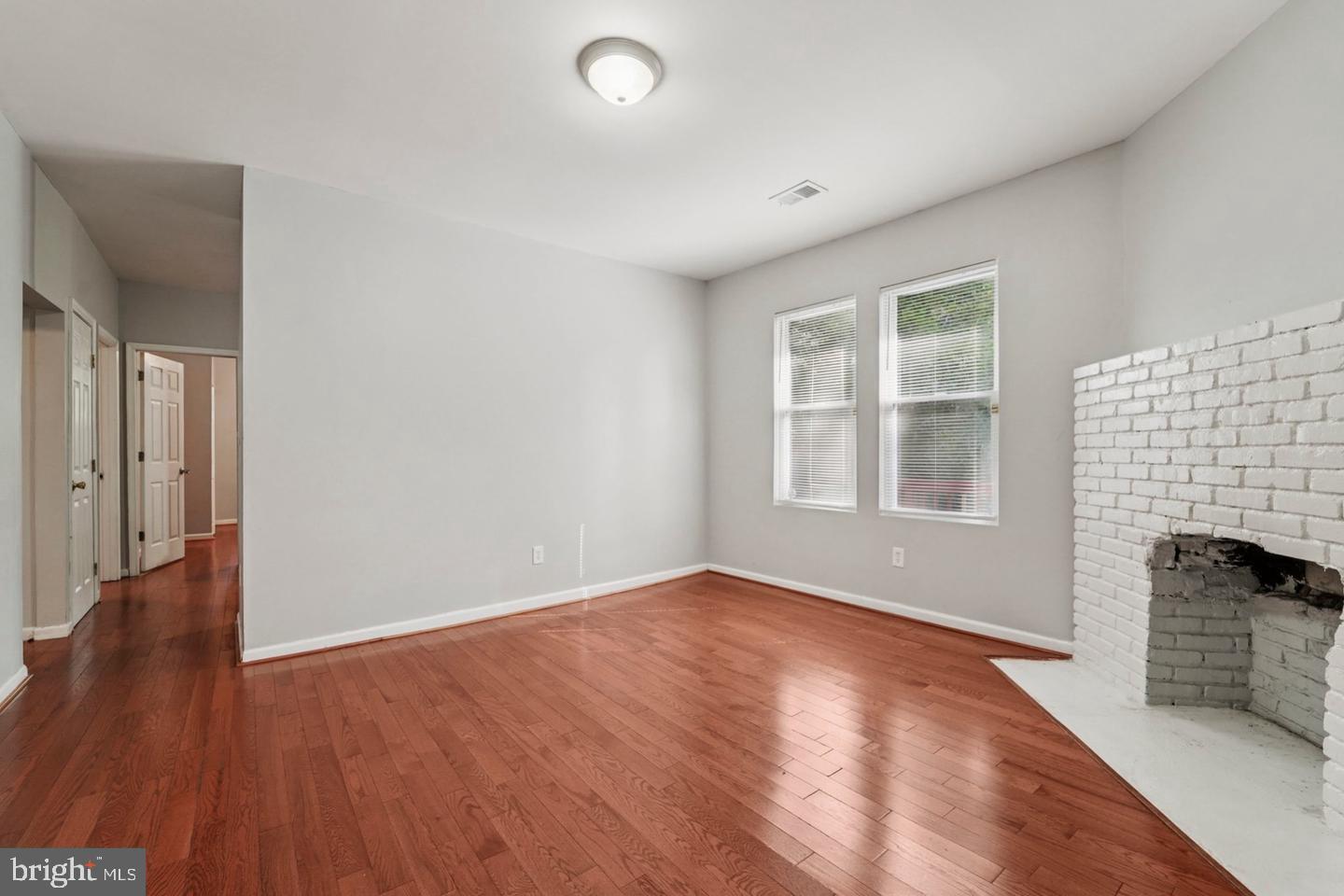 4511 Prospect Circle Baltimore, MD 21216 - Photo 11 of 25 an empty room with wooden floor and fireplace