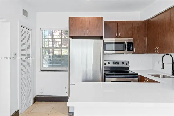 a kitchen with a refrigerator a stove a microwave and cabinets