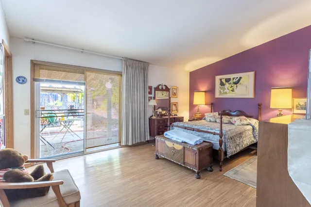 a living room with a bed and glass window