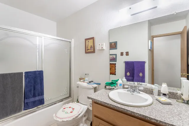 a bathroom with a granite countertop sink and a mirror with toilet