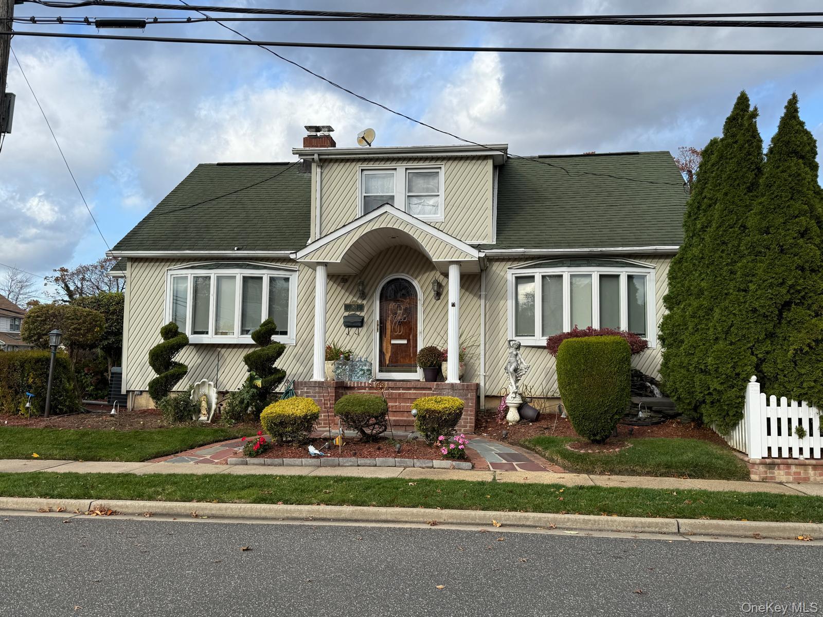 183 North Cottage Street Valley Stream, NY 11580 - Photo 3 of 16 View of front facade with a shingled roof and a chimney