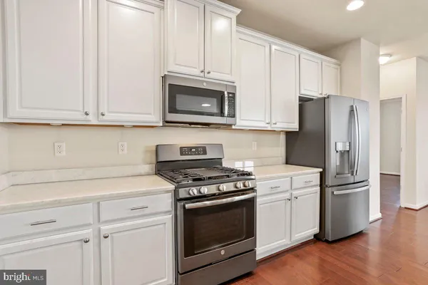 a kitchen with white cabinets and stainless steel appliances