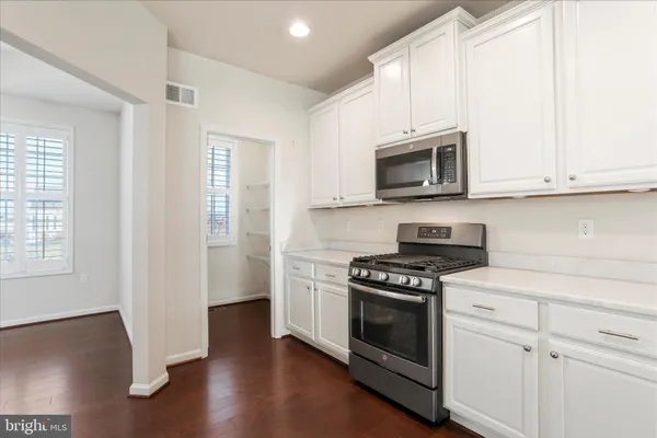 a kitchen with granite countertop white cabinets and black appliances