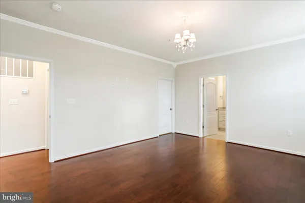 a view of an empty room with chandelier and a window