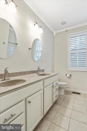 a spacious bathroom with a granite countertop sink a toilet and a mirror