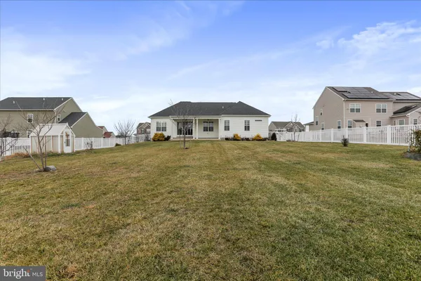 a view of a house with a big yard and large trees
