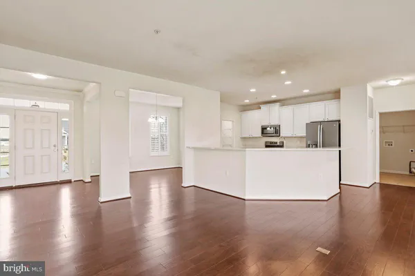 a view of a kitchen with refrigerator and wooden floor