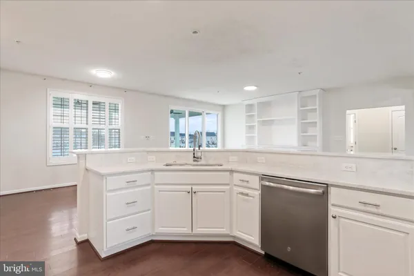 a kitchen with white cabinets and sink