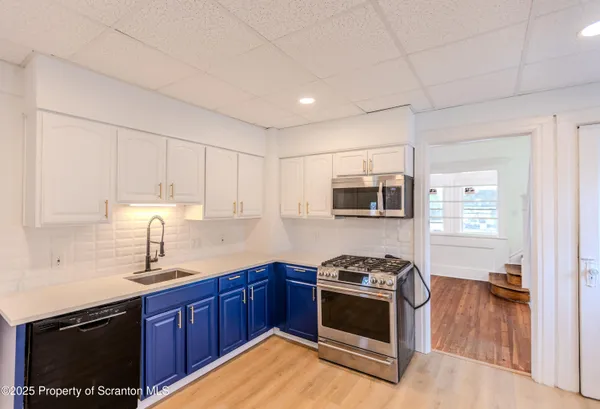 a kitchen with stainless steel appliances granite countertop a stove a sink and a microwave