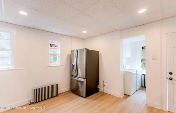 a kitchen with stainless steel appliances wooden floor and windows