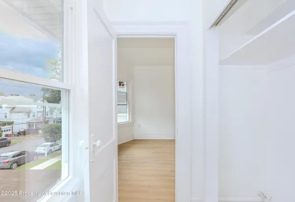a view of empty room with wooden floor