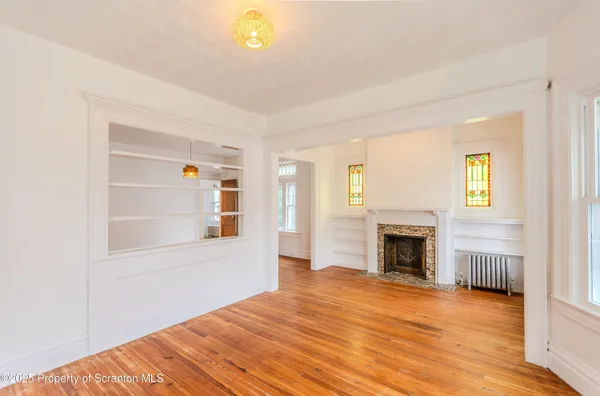 a view of empty room with wooden floor and fireplace