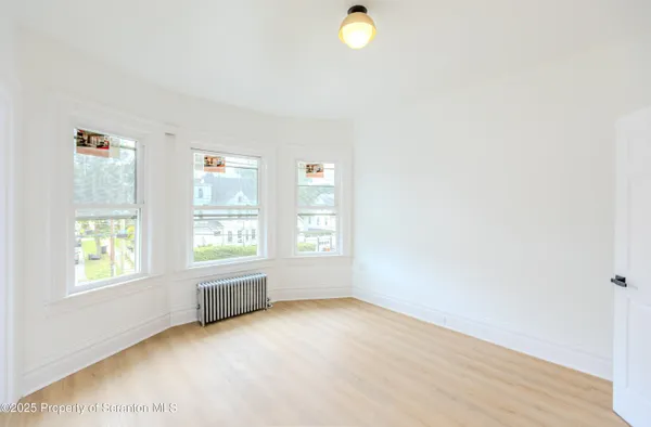 a view of a bedroom with wooden floor and a bathroom