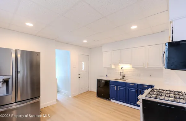 a kitchen with stainless steel appliances granite countertop a refrigerator and a stove top oven