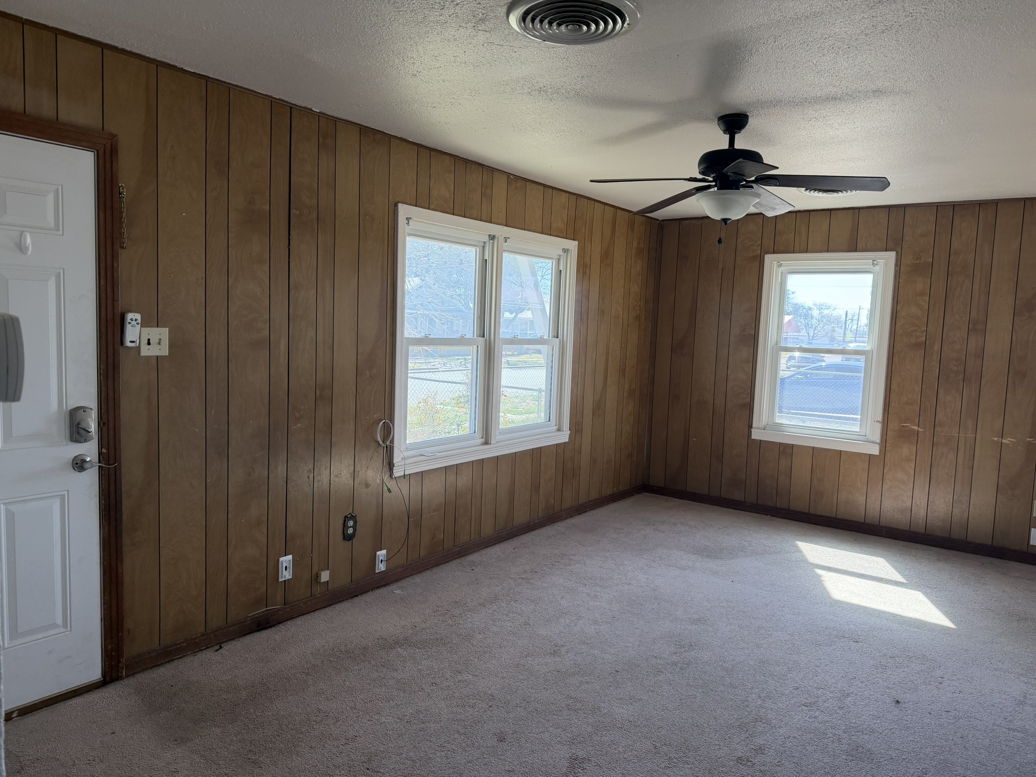 813 Northwest 1st Street Andrews, TX 79714 - Photo 2 of 13 an empty room with windows and fan