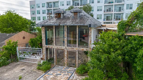 a view of a brick house with a large windows and plants