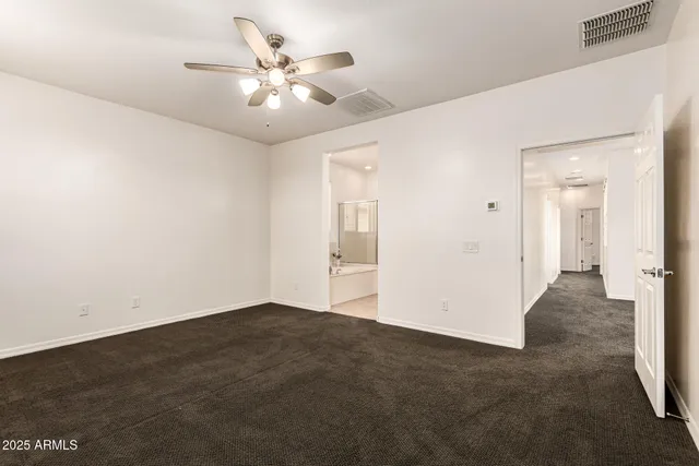 an empty room with fan and windows