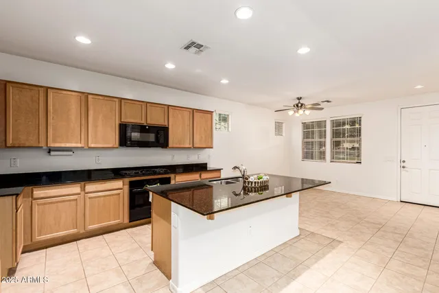 a kitchen with granite countertop a stove sink and cabinets