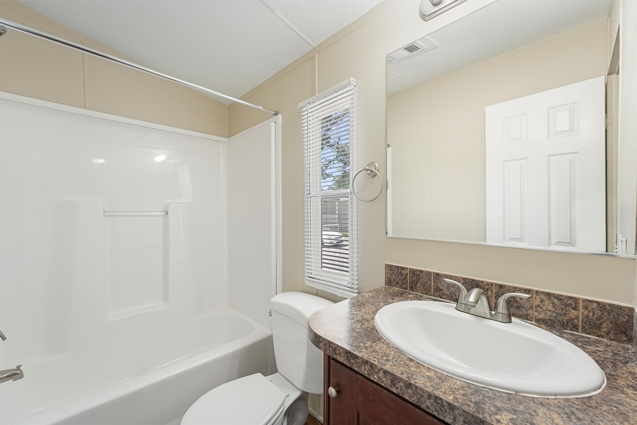 21864 Russell Drive New Caney, TX 77357 - Photo 14 of 15 a bathroom with a granite countertop sink a toilet a mirror and shower