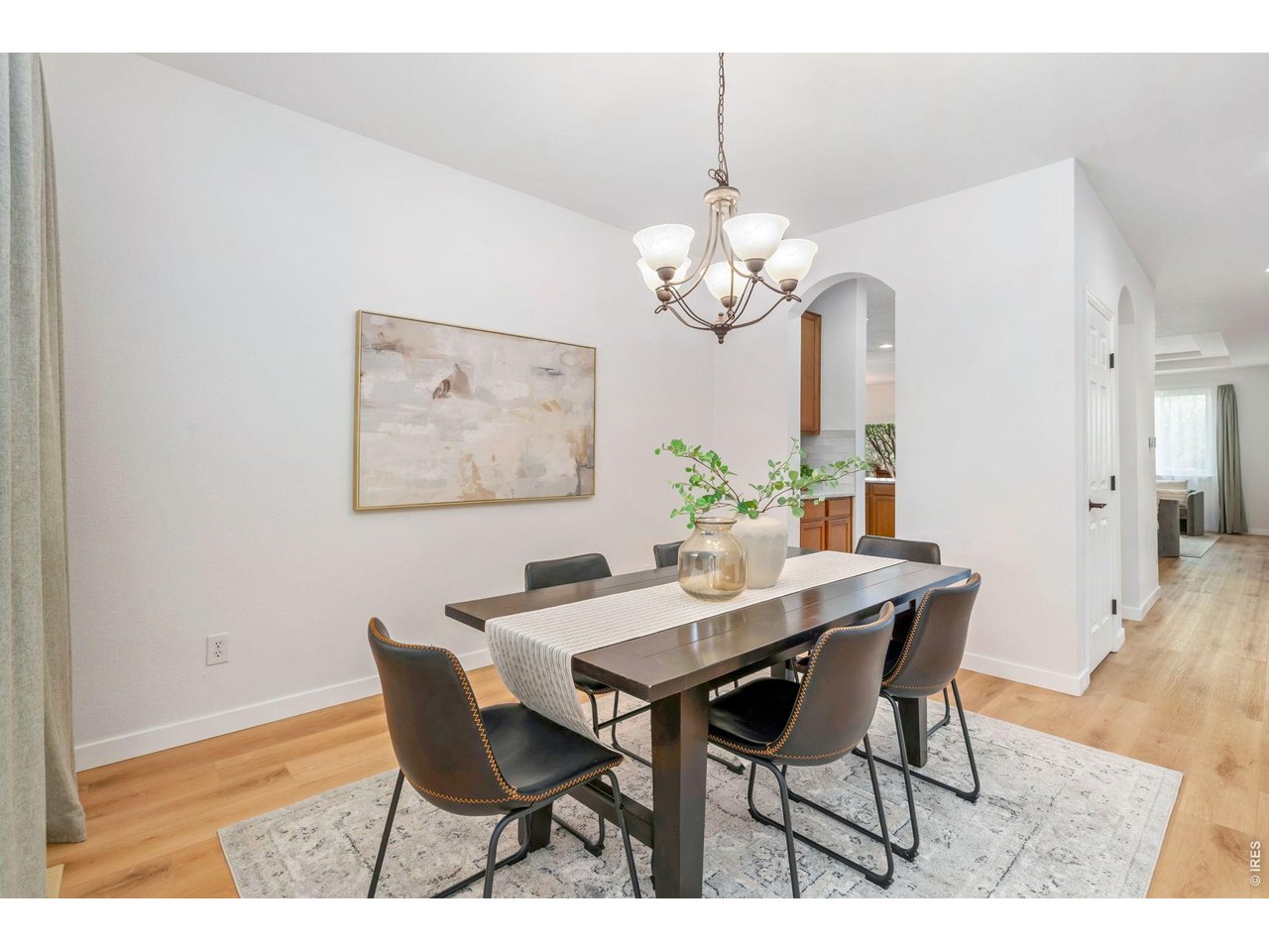 5574 Quarry Street Timnath, CO 80547 - Photo 15 of 43 a view of a dining room with furniture a chandelier and wooden floor