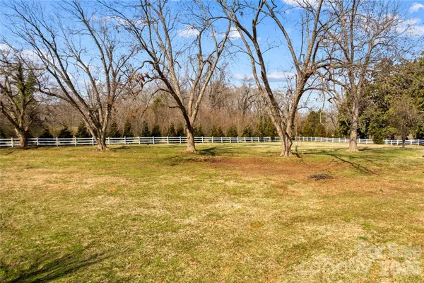 a view of house with outdoor space and covered with trees