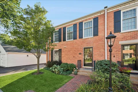 a front view of a house with a yard and trees