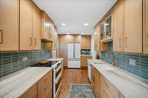 a kitchen with stainless steel appliances a sink stove and refrigerator