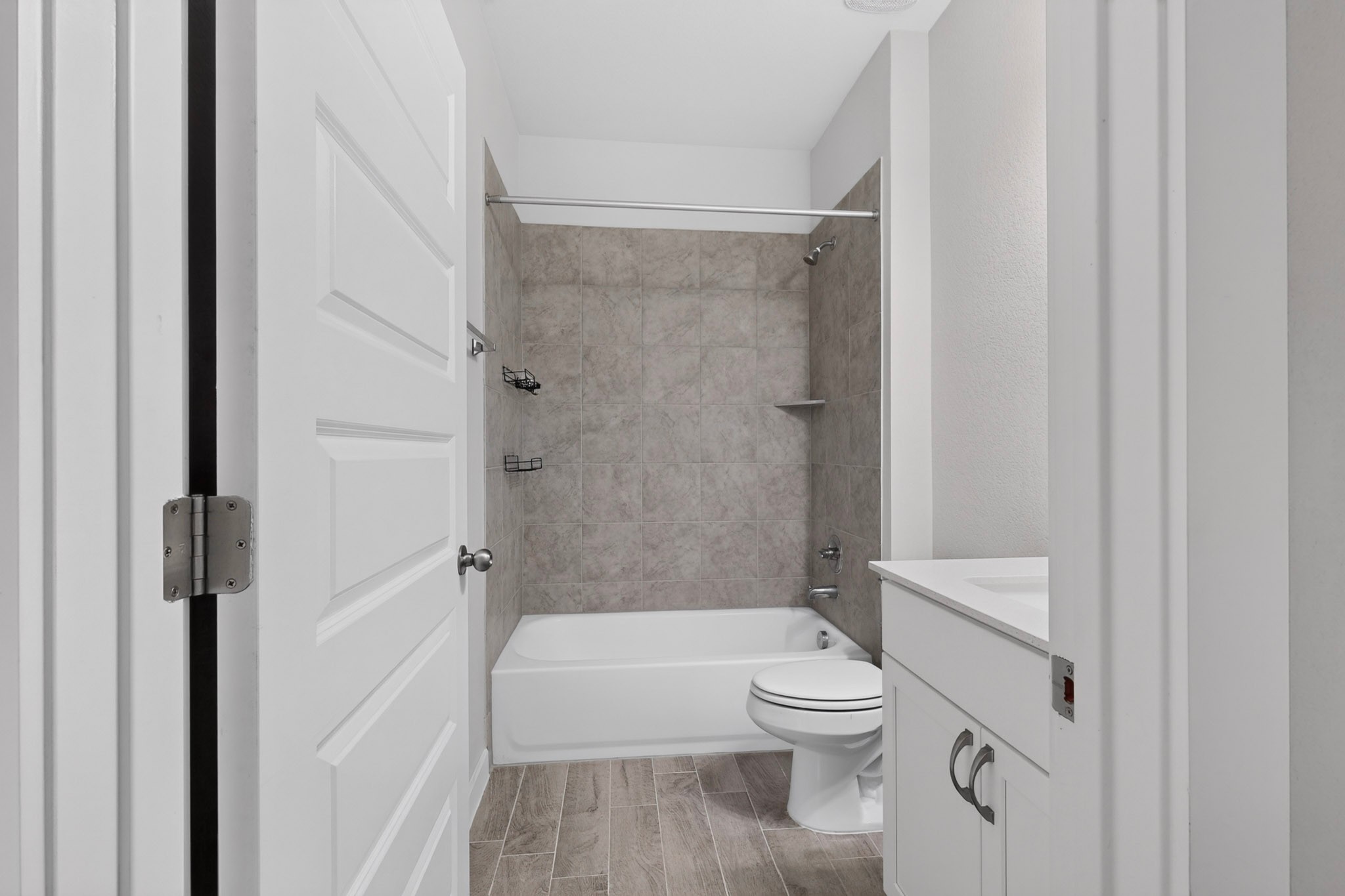 116 Appleberry Lane Elgin, TX 78621 - Photo 22 of 35 A well-appointed bathroom features a bathtub with a tiled shower surround and a clean vanity with a sink.