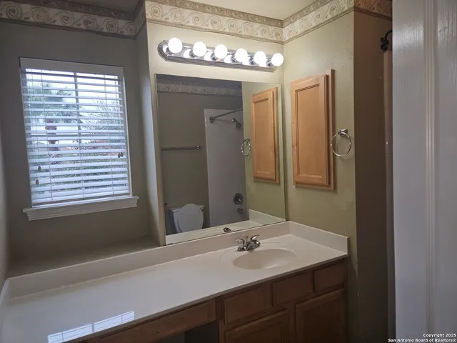 a bathroom with a granite countertop bathtub shower and toilet