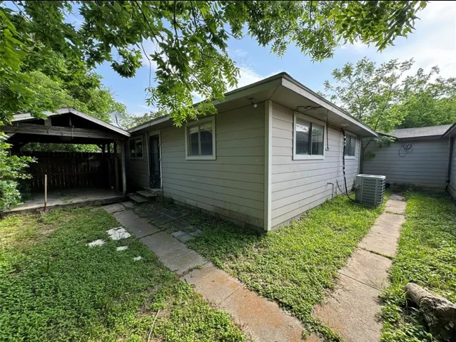 a backyard of a house with plants and barbeque oven