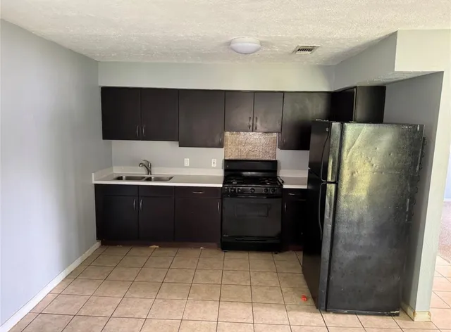 a kitchen with a refrigerator and a sink