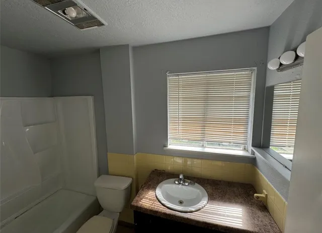 a bathroom with a sink toilet and mirror