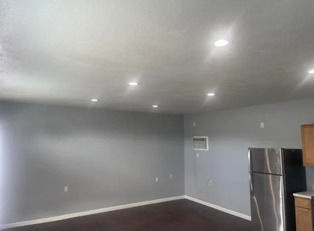 a view of a refrigerator in kitchen and a window